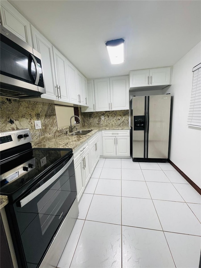 kitchen featuring white cabinets, appliances with stainless steel finishes, light tile patterned floors, and sink