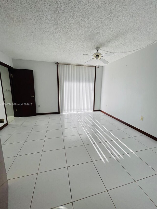 tiled spare room featuring ceiling fan and a textured ceiling