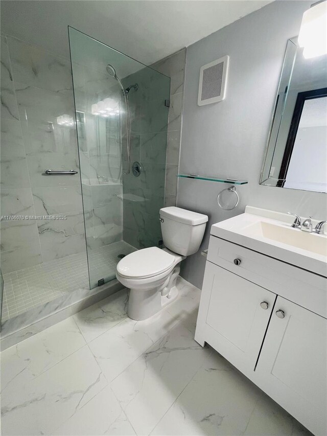 bathroom featuring tiled shower, vanity, and toilet