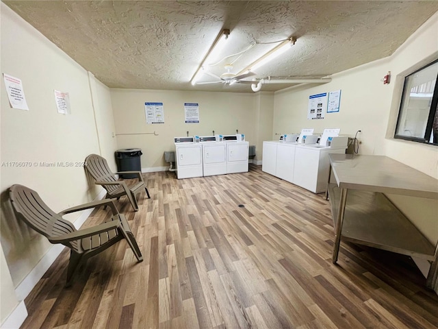 washroom with a textured ceiling, hardwood / wood-style flooring, and washer and clothes dryer