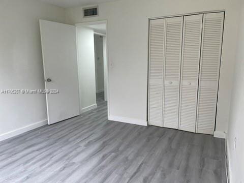 unfurnished bedroom featuring wood-type flooring and a closet