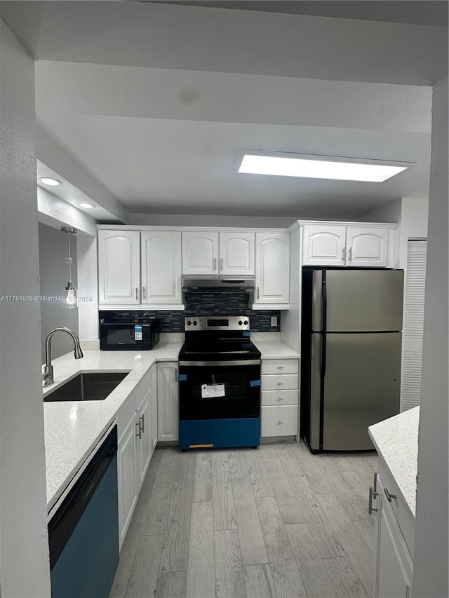 kitchen featuring light stone counters, stainless steel appliances, sink, light hardwood / wood-style flooring, and white cabinets