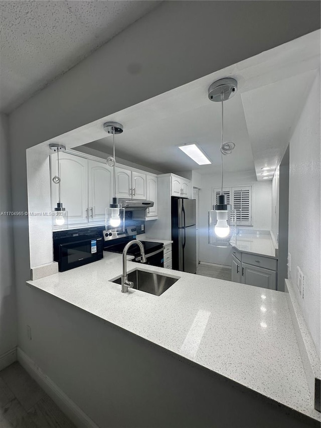 kitchen featuring kitchen peninsula, white cabinetry, hanging light fixtures, and appliances with stainless steel finishes