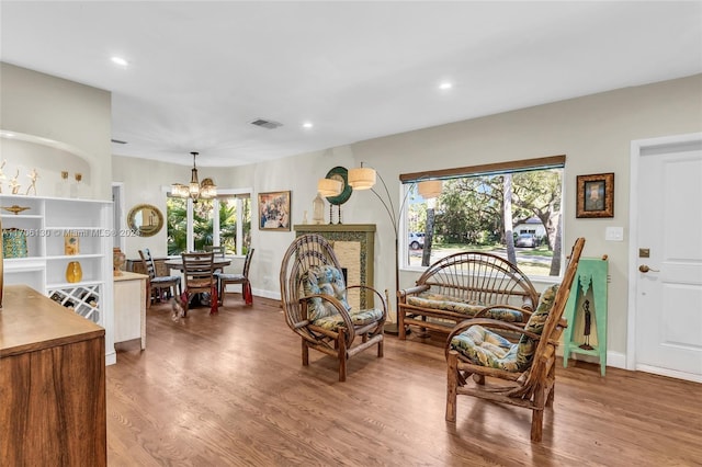 sitting room featuring hardwood / wood-style flooring, a wealth of natural light, and a notable chandelier