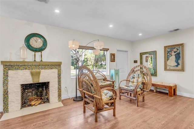 sitting room with a fireplace and light hardwood / wood-style floors