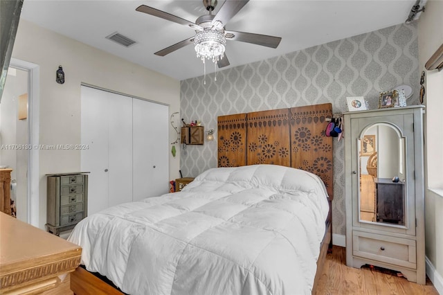 bedroom with light hardwood / wood-style flooring, a closet, and ceiling fan