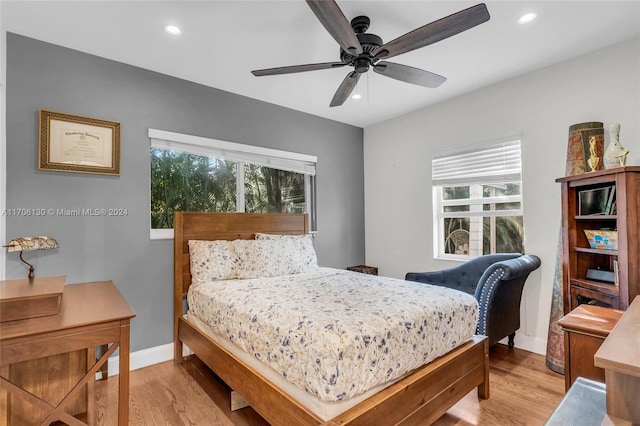 bedroom featuring multiple windows, ceiling fan, and light hardwood / wood-style flooring