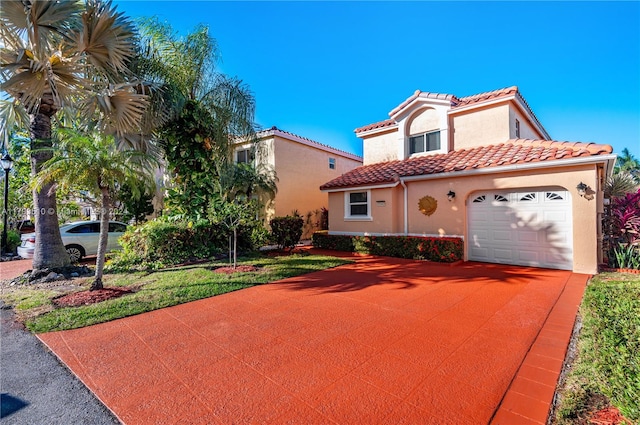 mediterranean / spanish home featuring a garage and a front yard