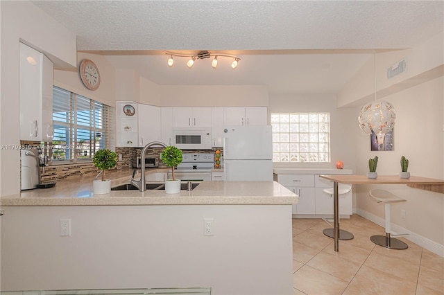 kitchen featuring kitchen peninsula, white cabinetry, a healthy amount of sunlight, and white appliances