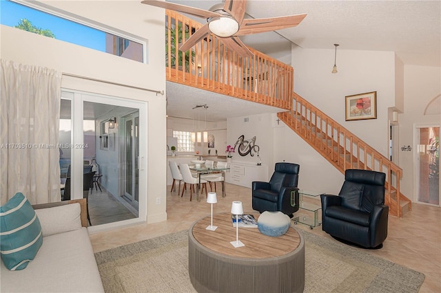 living room featuring light tile patterned flooring, a textured ceiling, and high vaulted ceiling