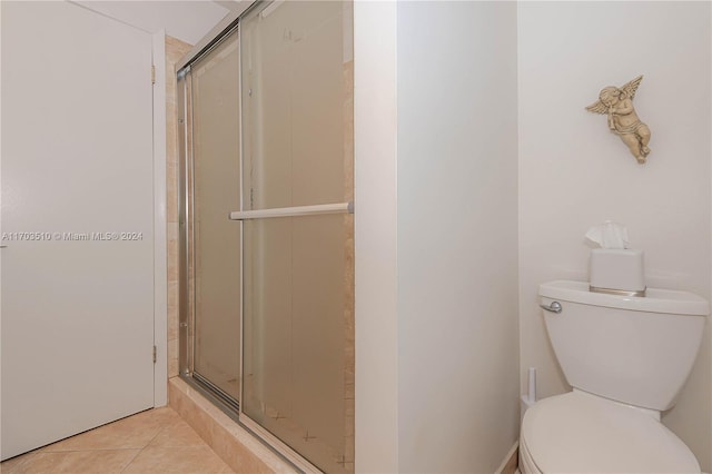 bathroom with tile patterned floors, toilet, and walk in shower