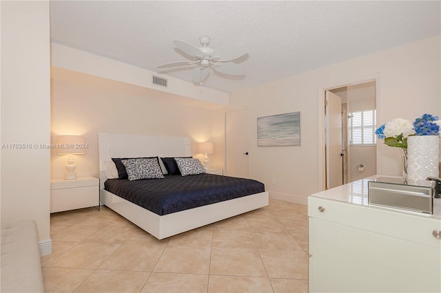 bedroom featuring a textured ceiling, ceiling fan, light tile patterned floors, and sink