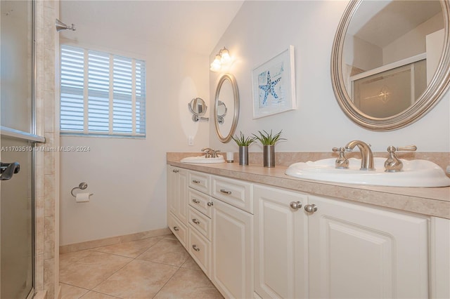 bathroom featuring tile patterned floors, vanity, a shower with shower door, and vaulted ceiling