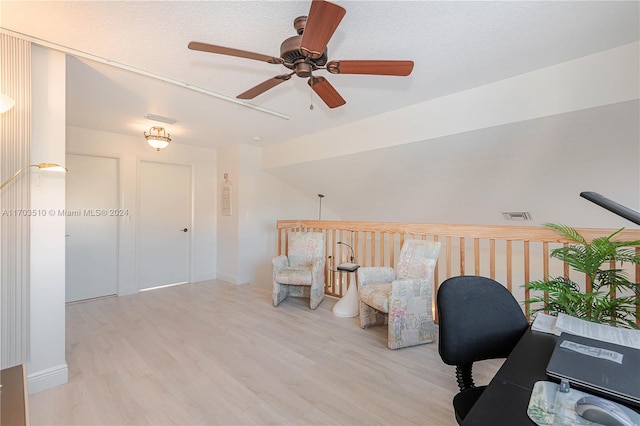 office featuring ceiling fan, light wood-type flooring, and a textured ceiling