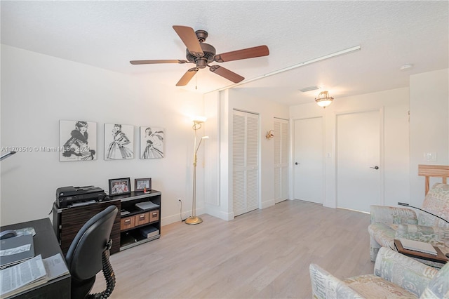 office area featuring ceiling fan, light hardwood / wood-style floors, and a textured ceiling