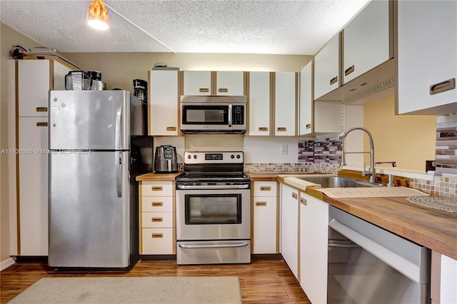 kitchen featuring light wood-type flooring, white cabinetry, a textured ceiling, and appliances with stainless steel finishes