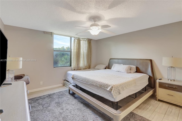 bedroom with ceiling fan and a textured ceiling