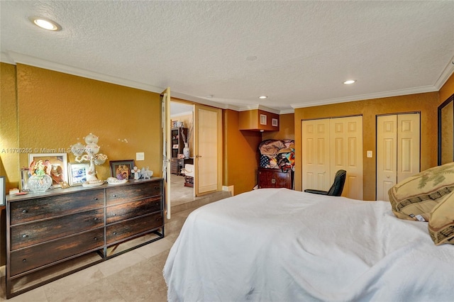 bedroom featuring a textured ceiling, multiple closets, and ornamental molding