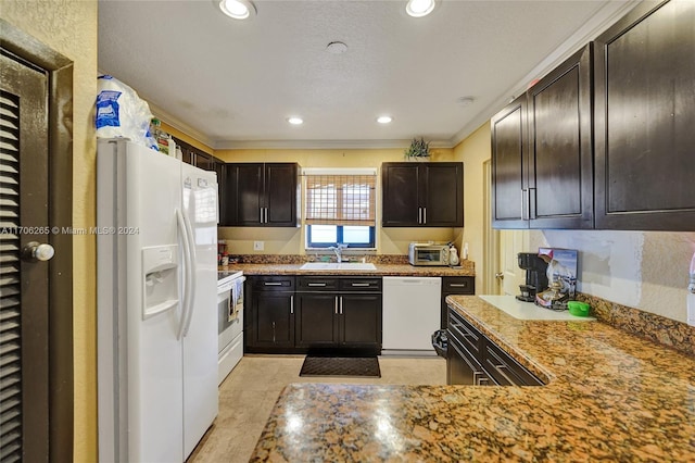 kitchen with light stone counters, ornamental molding, dark brown cabinets, white appliances, and sink