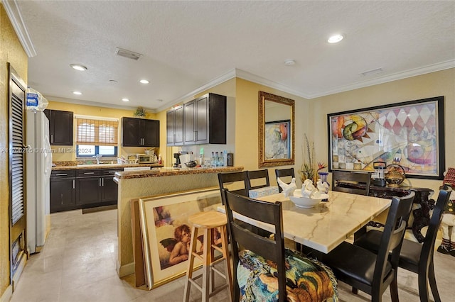 dining area featuring a textured ceiling and ornamental molding