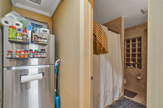 bathroom with crown molding, toilet, a textured ceiling, and a shower with shower curtain