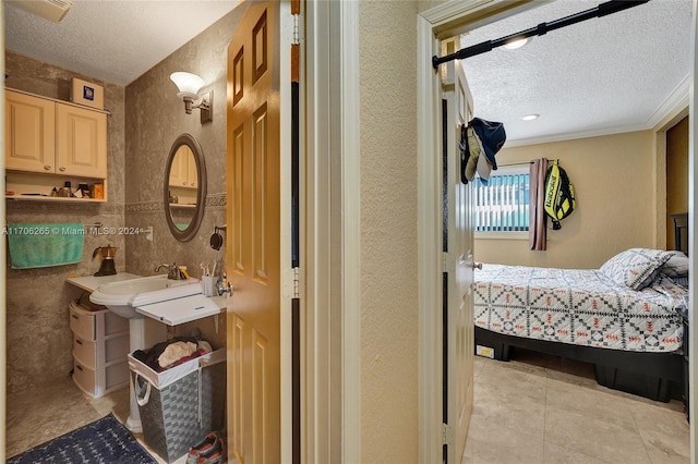 bathroom with a textured ceiling, tile patterned floors, and crown molding