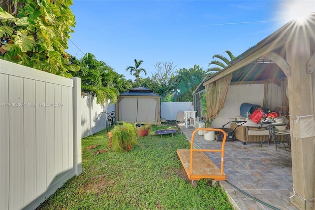 view of yard featuring a gazebo, a patio area, and a storage unit