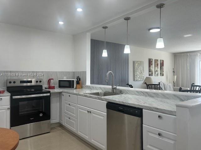 kitchen with white cabinetry, sink, stainless steel appliances, kitchen peninsula, and decorative backsplash