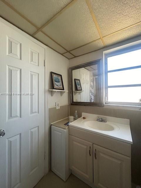 bathroom with a drop ceiling and vanity