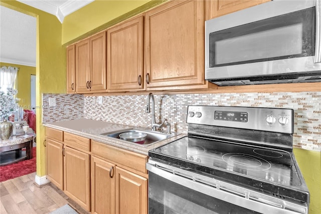 kitchen with stainless steel appliances, tasteful backsplash, crown molding, and sink