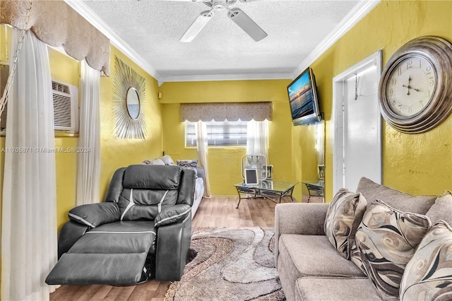 living room with ceiling fan, wood-type flooring, a textured ceiling, and ornamental molding