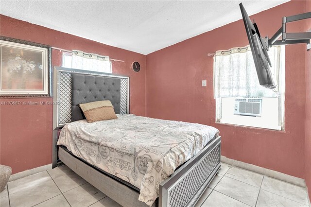 tiled bedroom with cooling unit and a textured ceiling