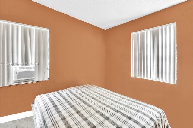 tiled bedroom featuring a textured ceiling and cooling unit