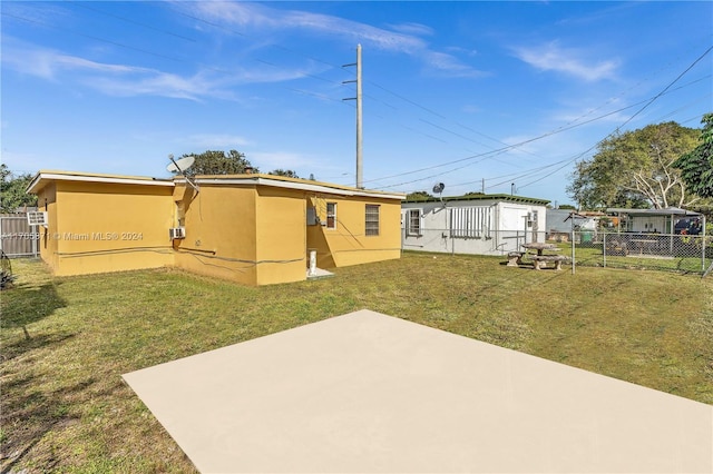 rear view of house featuring a lawn and a patio