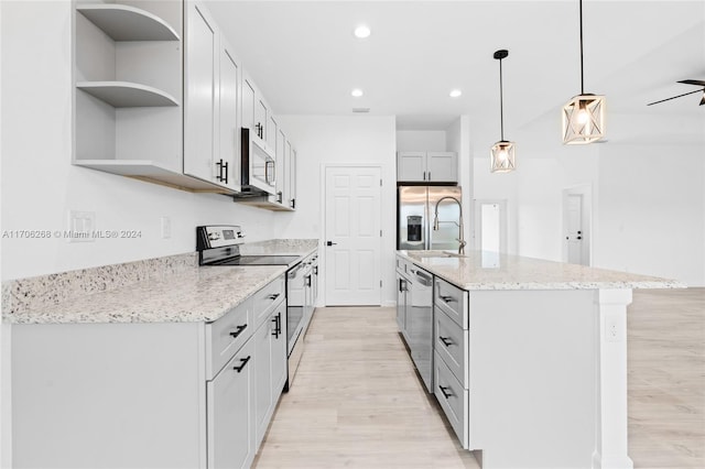 kitchen featuring ceiling fan, hanging light fixtures, an island with sink, light hardwood / wood-style floors, and appliances with stainless steel finishes