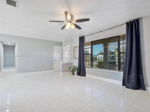 tiled spare room with ceiling fan