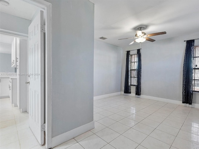 tiled spare room with ceiling fan