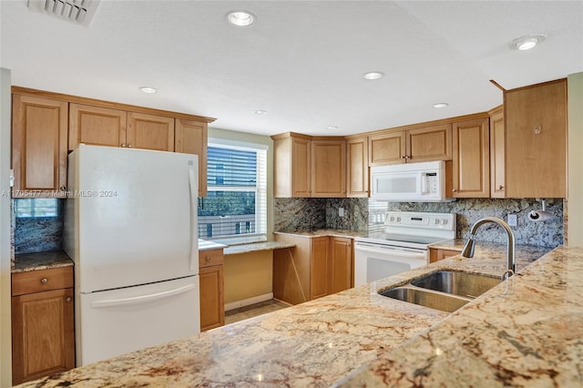 kitchen featuring decorative backsplash, light stone counters, white appliances, and sink