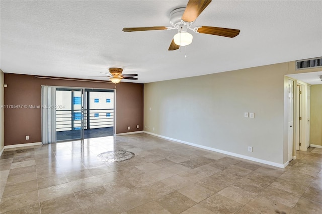 unfurnished room with ceiling fan and a textured ceiling