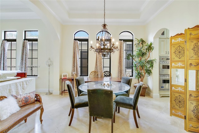 dining space with a raised ceiling, a chandelier, and ornamental molding