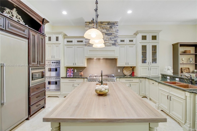 kitchen featuring sink, stainless steel appliances, decorative light fixtures, and ornamental molding