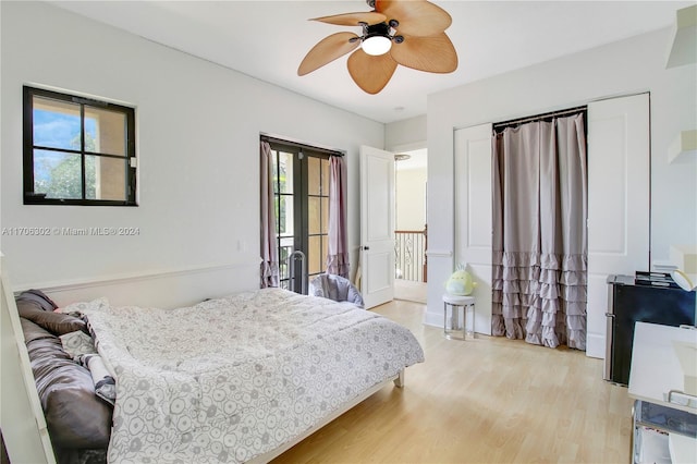 bedroom featuring ceiling fan, light hardwood / wood-style flooring, and multiple windows