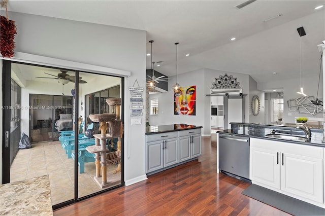 kitchen featuring ceiling fan, sink, dark hardwood / wood-style flooring, stainless steel dishwasher, and pendant lighting