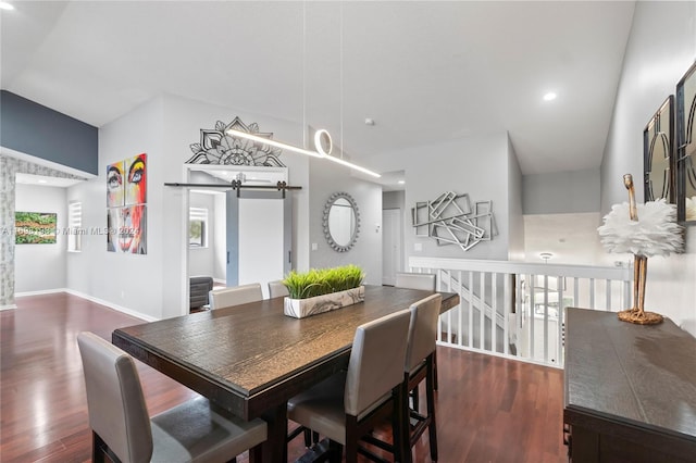 dining space with a barn door and dark hardwood / wood-style floors