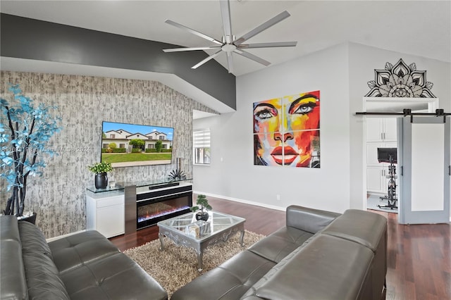 living room featuring lofted ceiling, a barn door, ceiling fan, and dark wood-type flooring