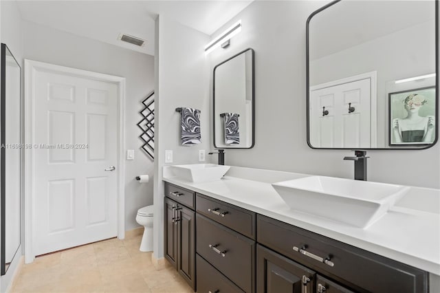 bathroom featuring tile patterned floors, vanity, and toilet