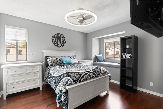 bedroom with a textured ceiling and dark hardwood / wood-style floors