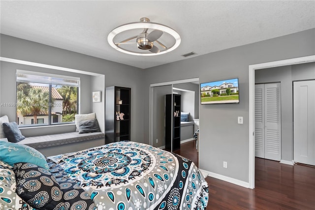 bedroom featuring ceiling fan, dark wood-type flooring, and a textured ceiling