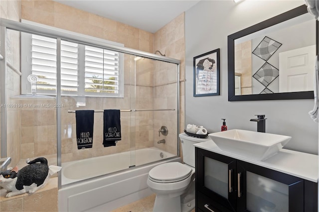 full bathroom featuring tile patterned floors, vanity, toilet, and bath / shower combo with glass door