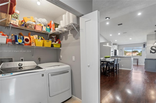 laundry room with a textured ceiling, washer and dryer, and dark wood-type flooring